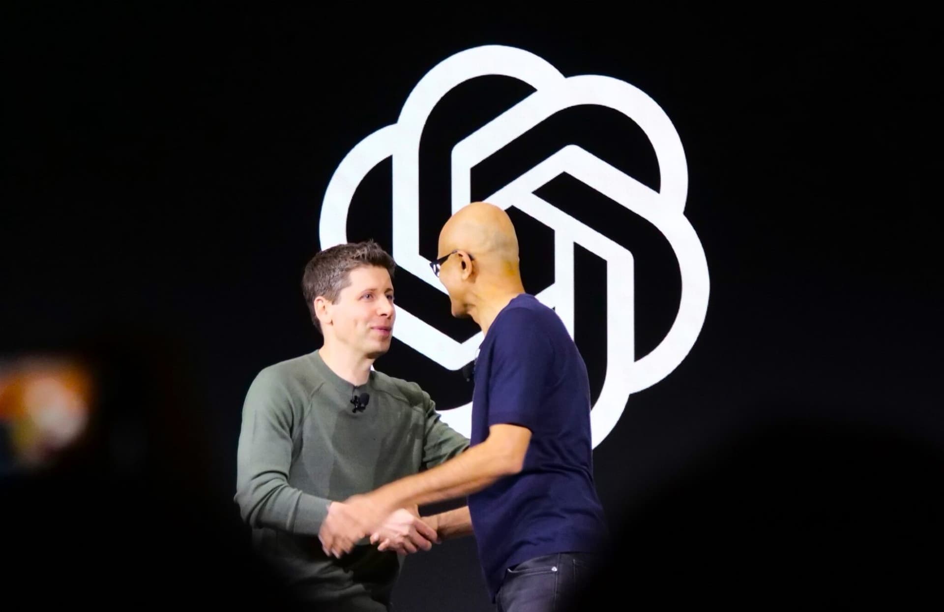 Sam Altman greets Microsoft CEO Satya Nadella at OpenAI DevDay in San Francisco in 2023. (GeekWire File Photo / Todd Bishop)