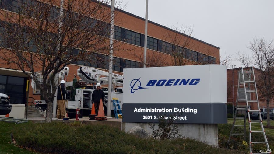 Workers at Spirit AeroSystems replace the sign outside the company's headquarters with a Boeing sign on Friday, Dec. 5, 2025
